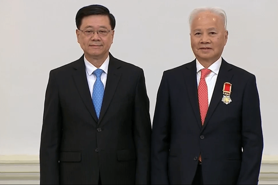 李家超向楊釗頒發大紫荊勳章。港台FB影片截圖