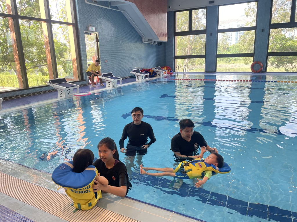史丹福游泳学校教练悉心指导体验班学员水中技巧。
