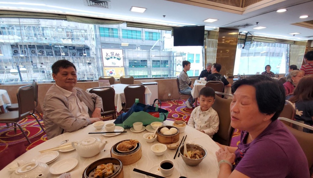 謝太（右）與丈夫和男孫來飲茶。