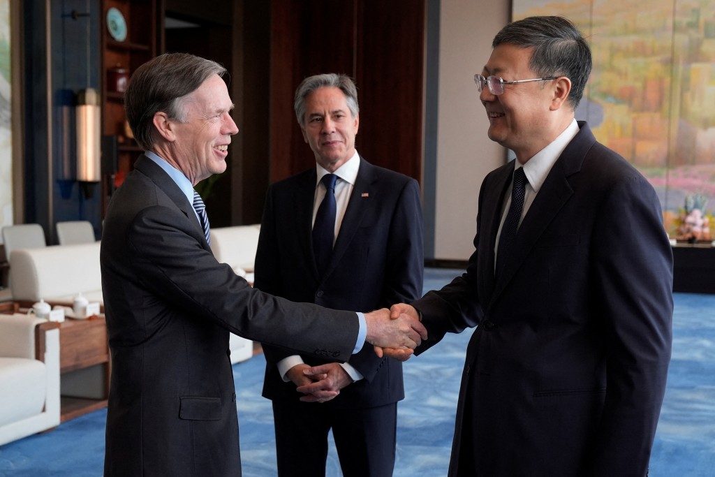 美国国务卿布林肯（中）在大会堂看著美国驻华大使伯恩斯（左）与上海市委书记陈吉宁握手。 路透社
