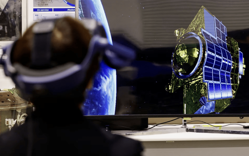 2024 年 1 月 19 日，在日本东京南部相模原市的日本宇宙航空研究开发机构 (JAXA) 设施中，一名佩戴 VR 设备的记者尝试模拟月球勘测智能著陆器 (SLIM) 的登月。路透社