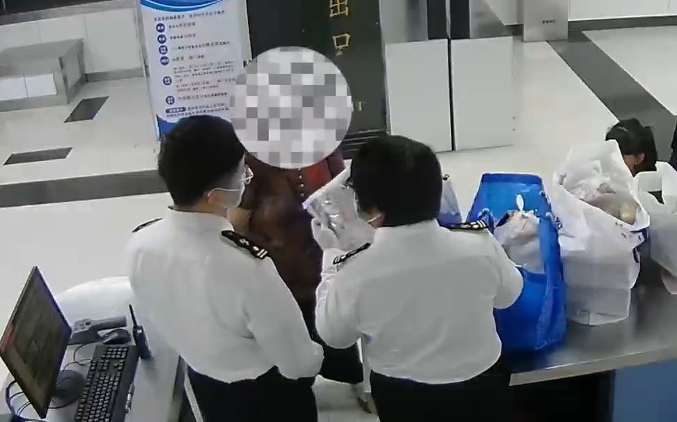 關員在婦人行李上發藥藥片。海關發布 關員在婦人行李上發藥藥片。海關發布
