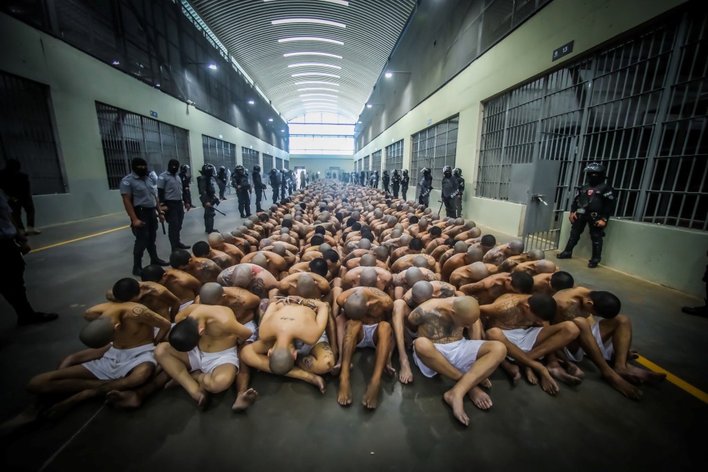 囚犯人贴人蹲下来等候安排进入牢房。 路透社