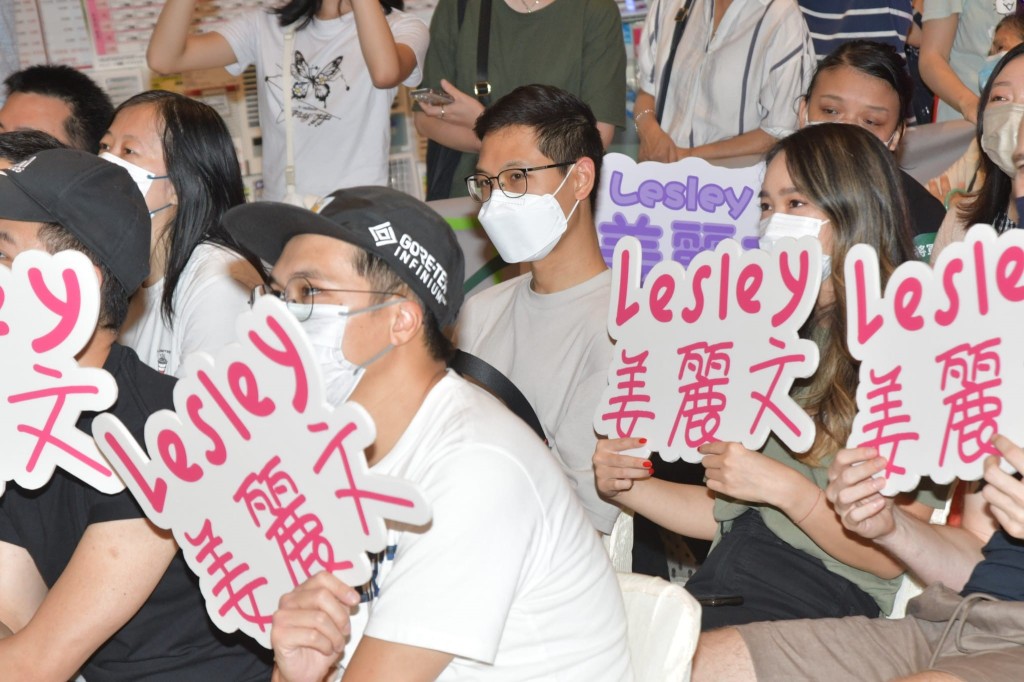 姜丽文的老公穿上灰色衫，坐在粉丝堆中支持太太。