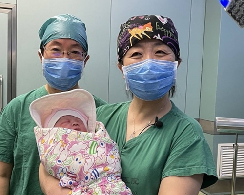 手術室醫護人員與這名來之不易的女嬰合照。互聯網圖片