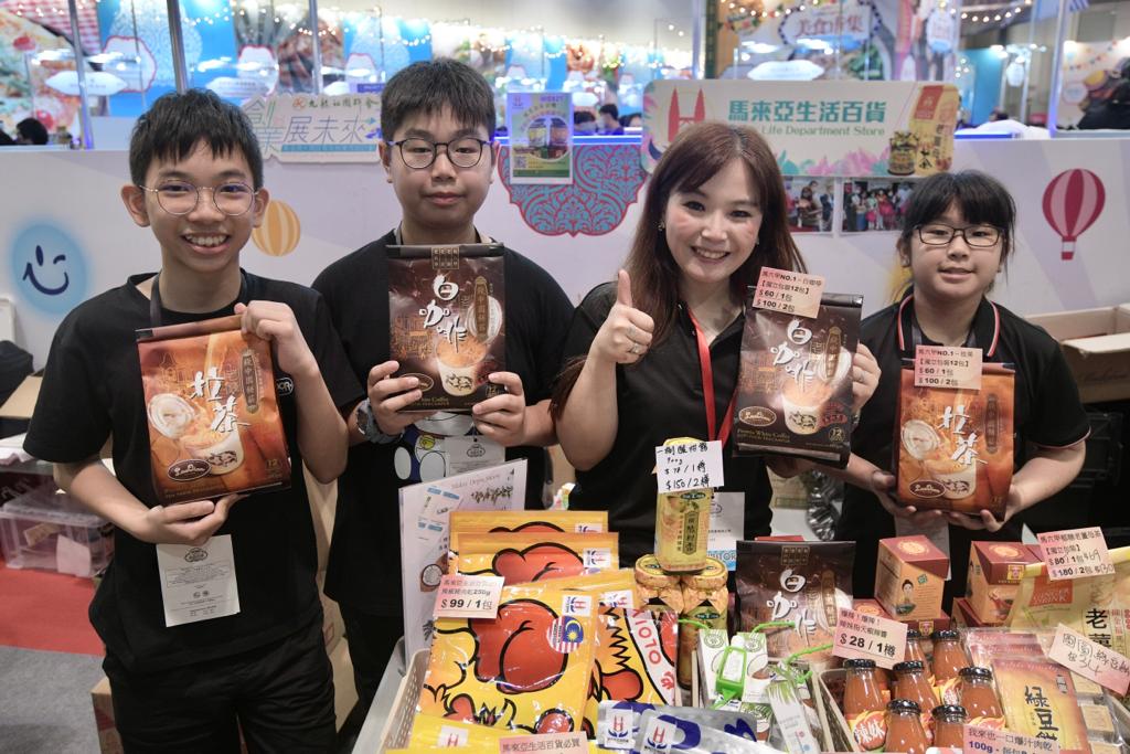 谭小姐(右二)的摊位以售卖马来西亚食品为主，她表示活动可为香港发放开心正能量。陈浩元摄