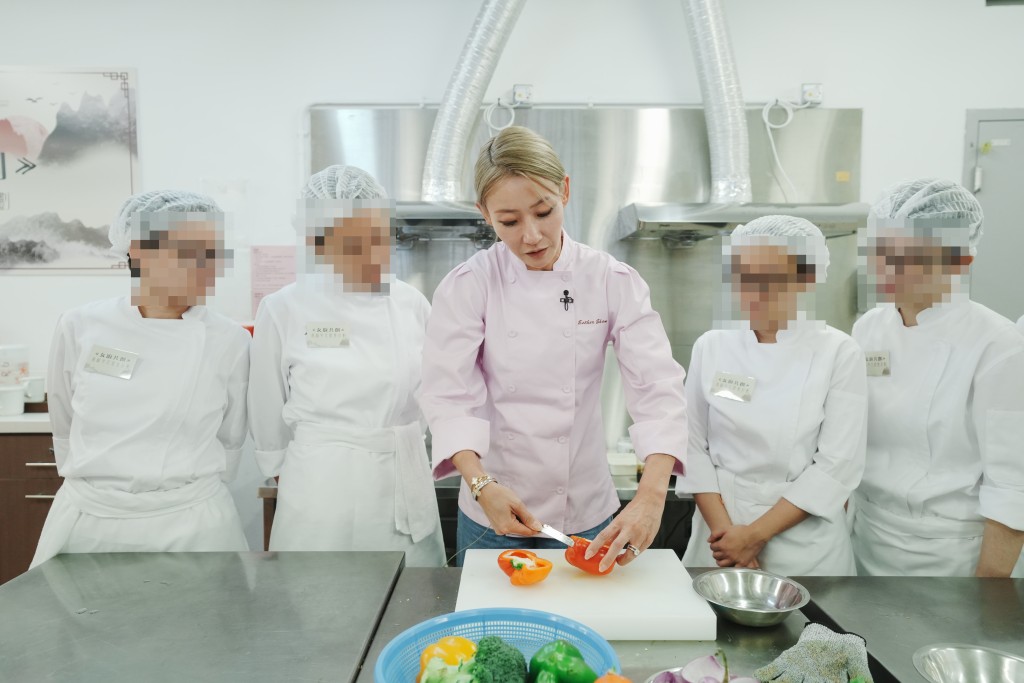 「仁膳」項目發起人沈依紅（中）向學員親自傳授廚藝，她認為職業培訓有助推動在囚人士的更生工作，期望計劃能夠引起各界迴響，共同為更生人士創造更多就業機會。