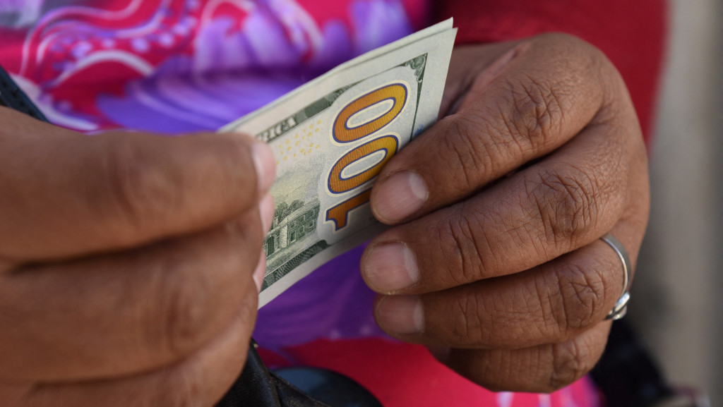 玻利維亞拉巴斯一名街頭兌換商手持100美元紙幣。 路透社