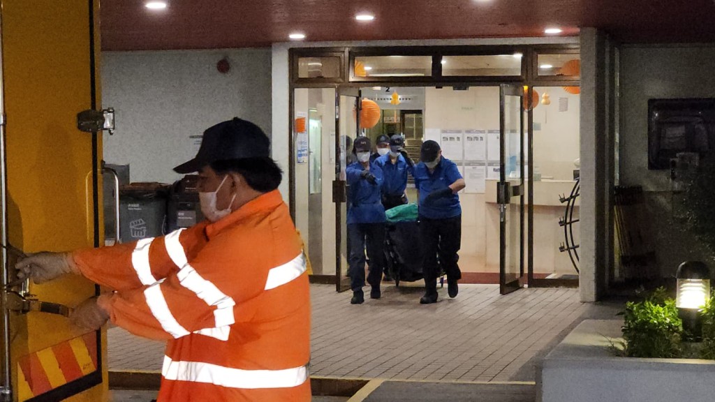 仵工將女死者遺體移送往殮房。黎志偉攝 仵工將女死者遺體移送往殮房。黎志偉攝