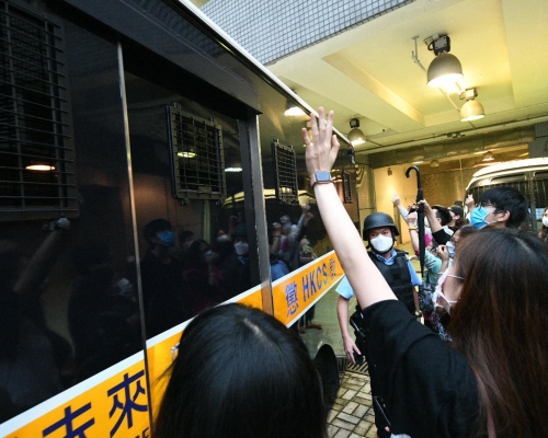 有到場聲援的人士向被告揮手