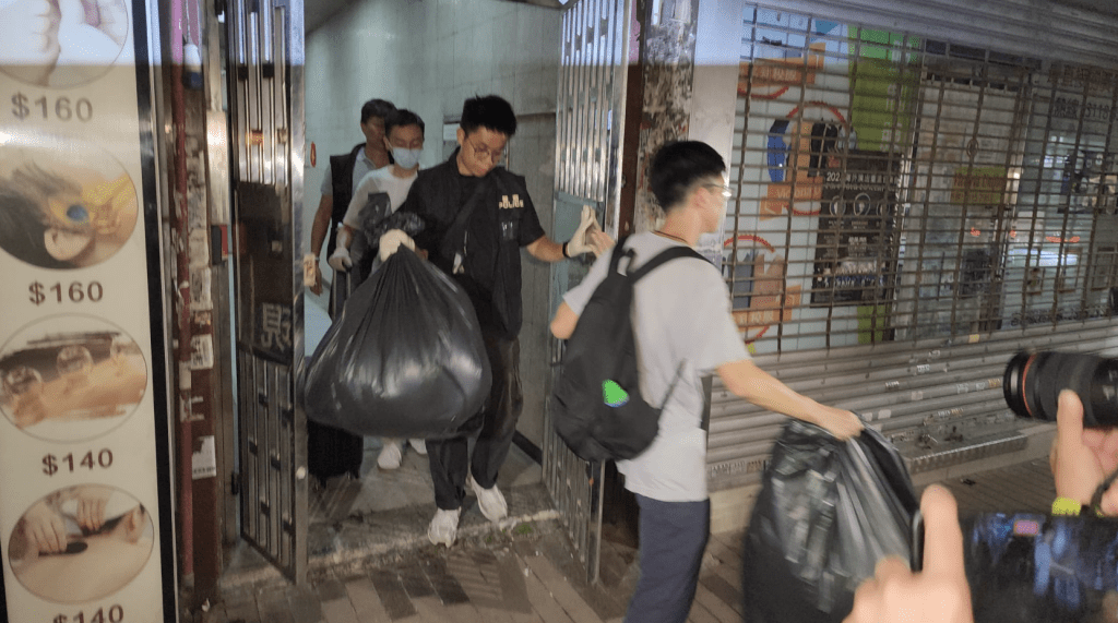 警方晚上從案發單位取走多袋證物。黎志偉攝 警方晚上從案發單位取走多袋證物。黎志偉攝