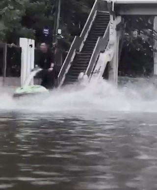 市區有民眾苦中作樂,在淹水街頭衝浪、捉魚。X 市區有民眾苦中作樂,在淹水街頭衝浪、捉魚。X