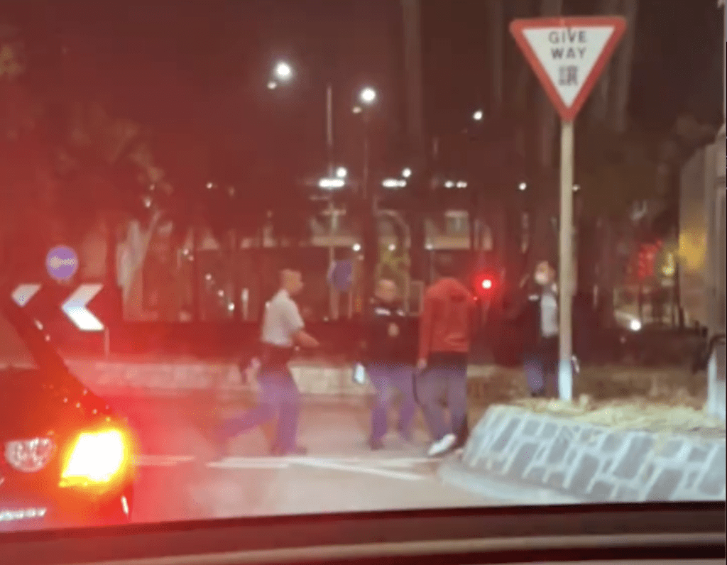 一名男子在馬路中與警員對峙。網上片段截圖