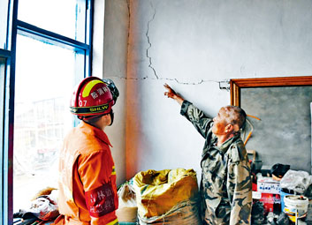 ■地震過後，救援人員查看房屋受損情況。