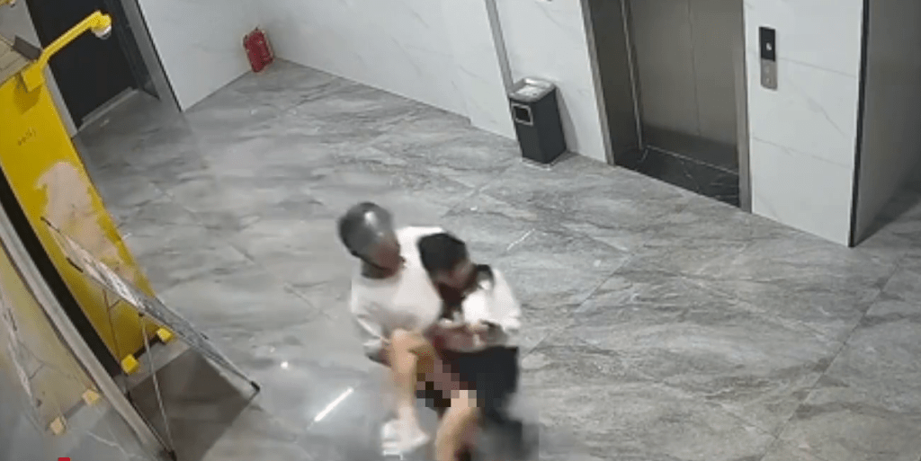 「頭盔男」強行將女子抱起,女子不停掙扎。 「頭盔男」強行將女子抱起,女子不停掙扎。
