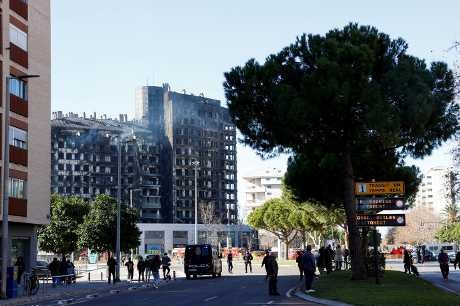 瓦倫西亞市兩幢住宅樓燒通頂。火災翌日附近市民遠望災情。路透社 