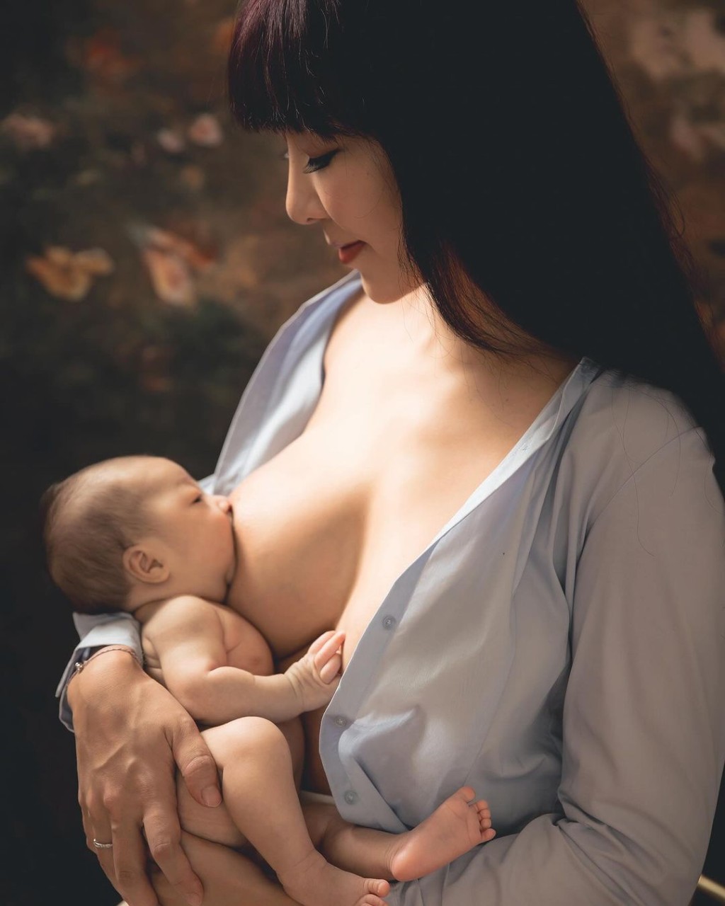 李宓穿上一件淺藍色襯衫，不過就將扣子解開露出35F傲人上圍，並將剛出生的雙胞胎女兒放在大腿上餵母乳及遮住重點部位。