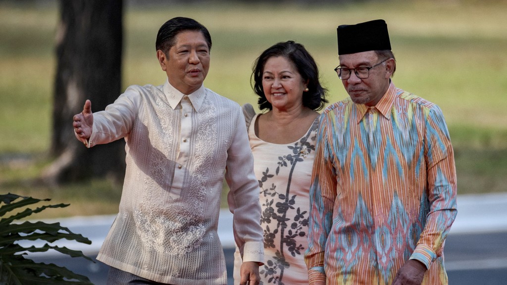 菲律賓總統馬可斯和夫人麗莎訪問馬來西亞，獲首相安華（右）接待。  路透社