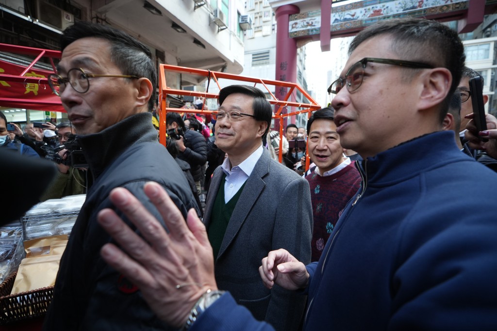 杨润雄(左)等陪同李家超到庙街市集视察。刘骏轩摄