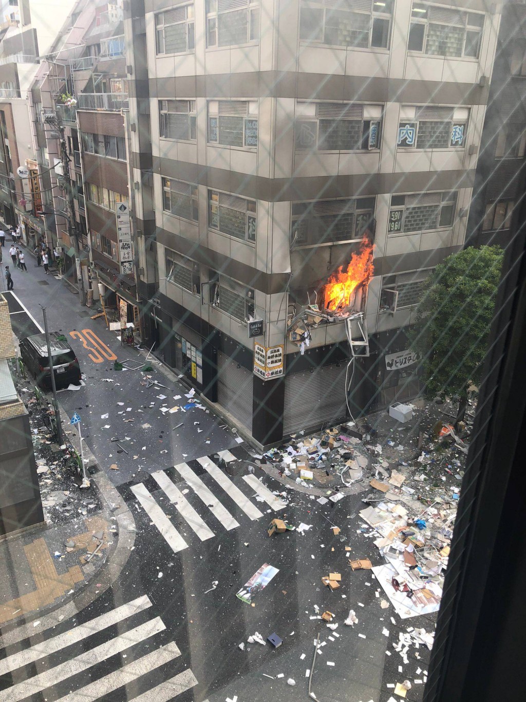 爆炸後，有單位著火，雜物散落馬路。(twitter：ハン @q842804169)
