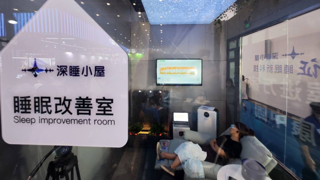 2022年7月28日，觀眾在海口體驗「深睡小屋」，屋內的設備用於改善睡眠質量。新華社