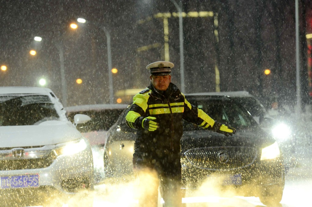 全國多地迎來降雪，2月1日，交警冒雪在河南省駐馬店市汝南縣指揮交通。 新華社