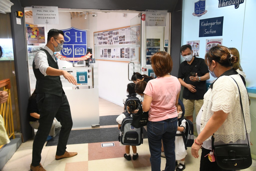 德萃幼稚園部及小學部總校長朱子穎在校門迎接學生。