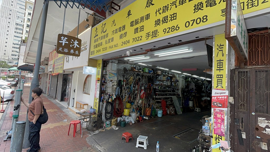車房老闆娘替店前車輛入錶。楊偉亨攝
