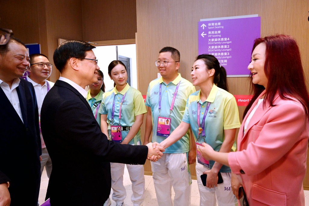 李家超（前排左二）與杭州第19屆亞洲運動會志願者交流。政府新聞處