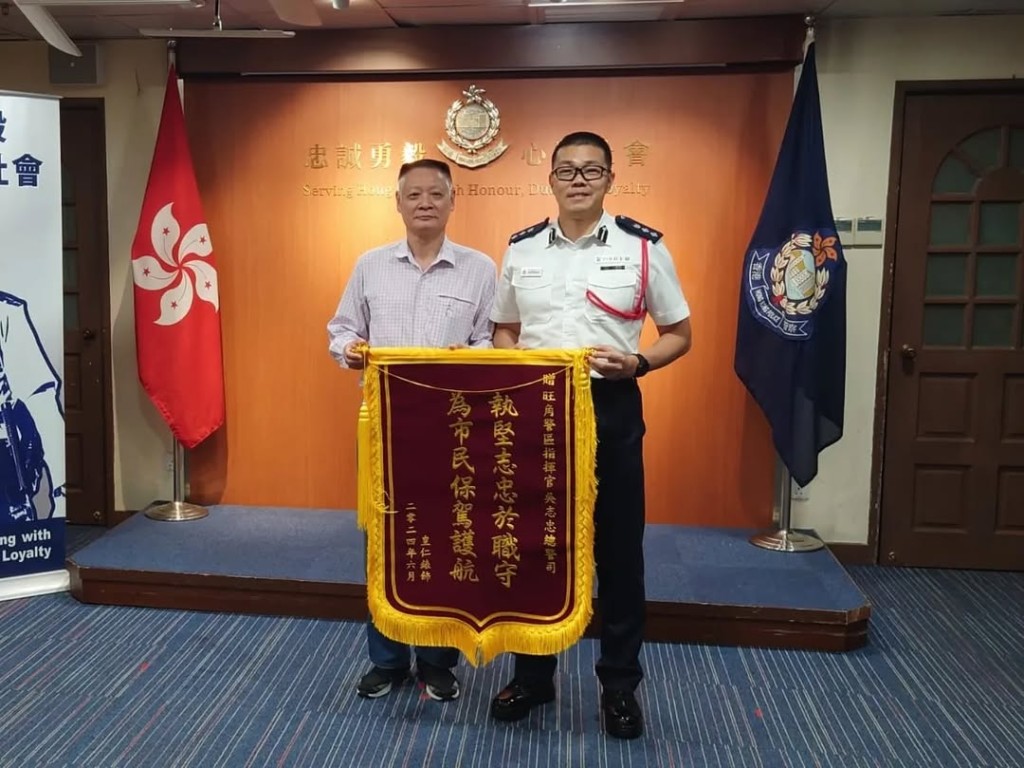 吳志忠代表旺角警區刑偵人員接受市民贈予的錦旗。 吳志忠代表旺角警區刑偵人員接受市民贈予的錦旗。
