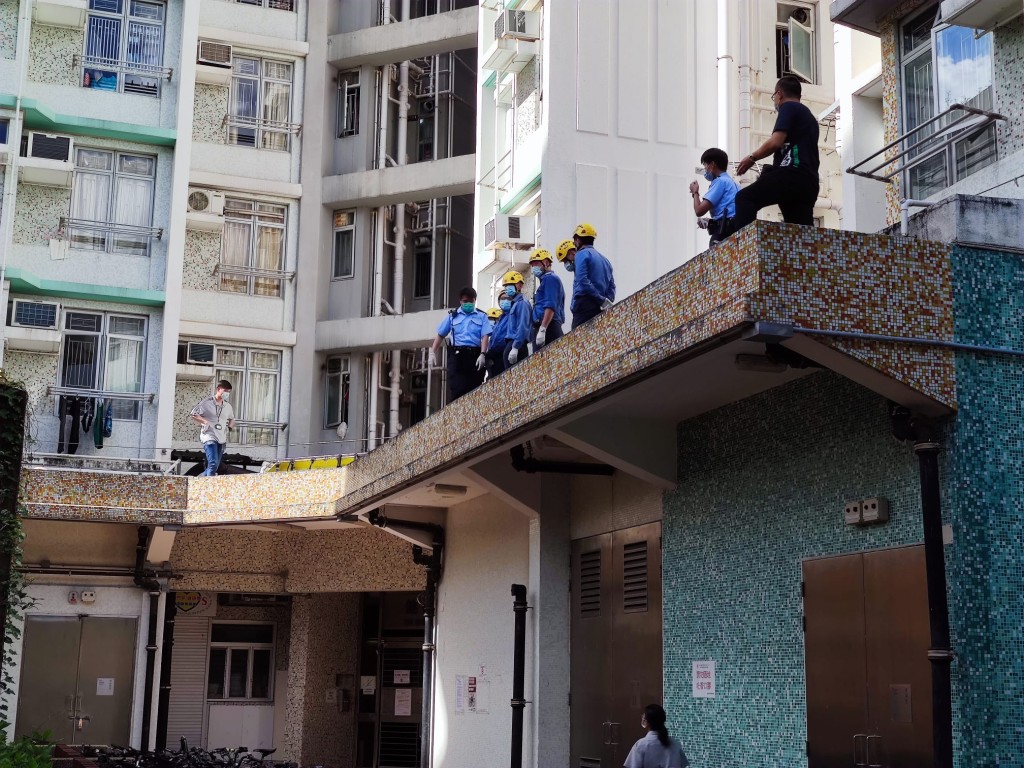 女子倒斃平台，消防協助將死者遺體運到地面。 梁國峰攝