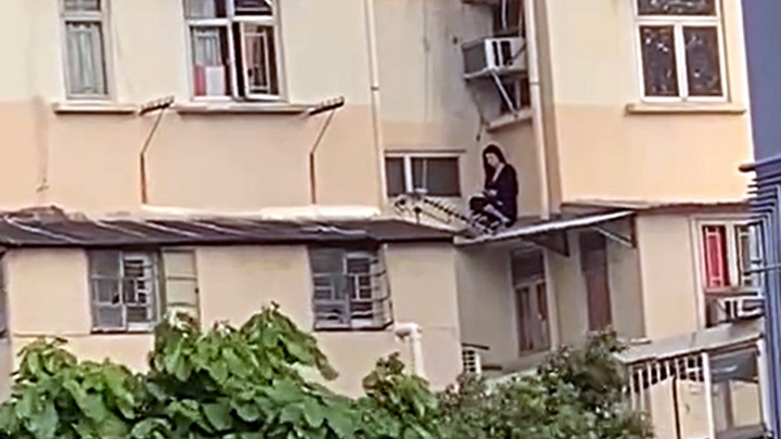女子被困大厦簷篷顶。网图