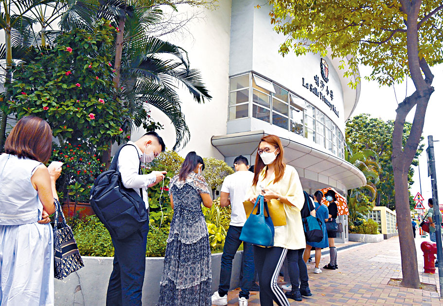 小一自行收生階段昨展開，有家長提早到喇沙小學門外排隊，輪候遞交申請表。　