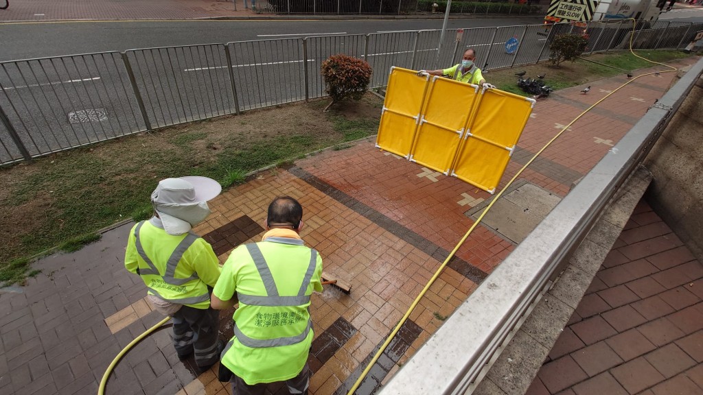 清潔工人清洗行人路鴿屎。