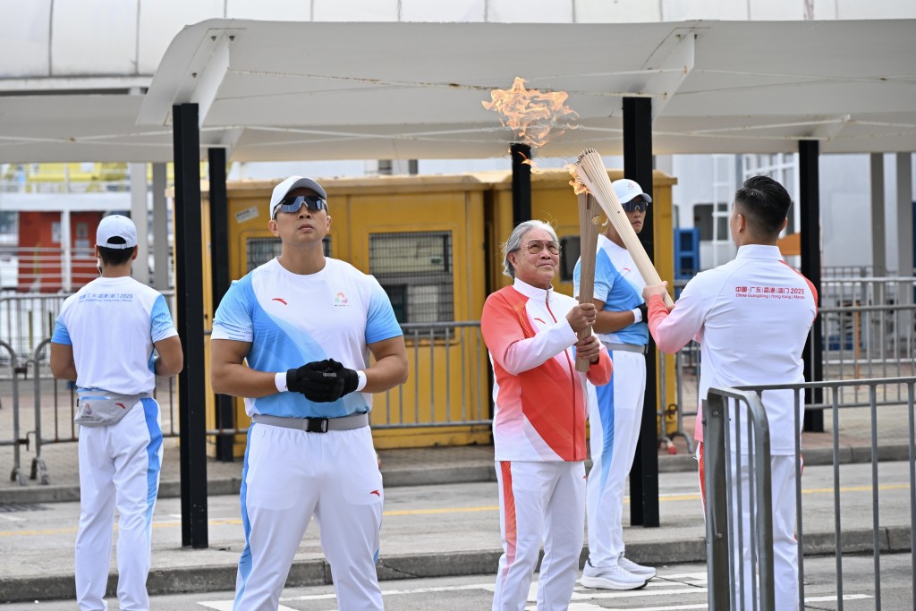 在灣仔金紫荊一帶,第16棒火炬手、港協暨奧委會會長霍震霆接過火炬。蘇正謙攝 在灣仔金紫荊一帶,第16棒火炬手、港協暨奧委會會長霍震霆接過火炬。蘇正謙攝