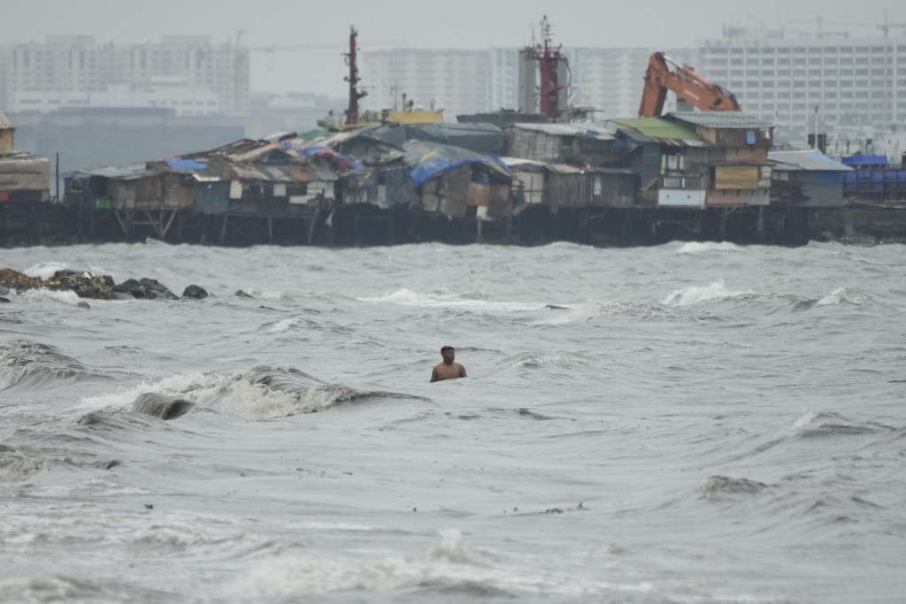 当台风奥鹿接近菲律宾马尼拉通多海滨贫民区时，仍有一名居民沿著强浪游泳。AP