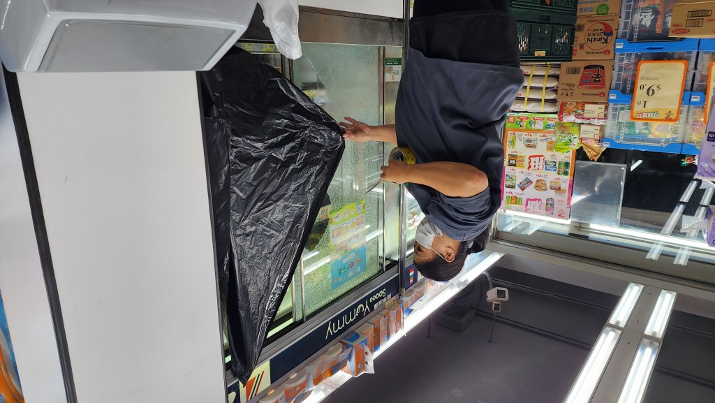 職員用黑色膠袋將受損凍櫃門遮蓋。黃文威攝 職員用黑色膠袋將受損凍櫃門遮蓋。黃文威攝