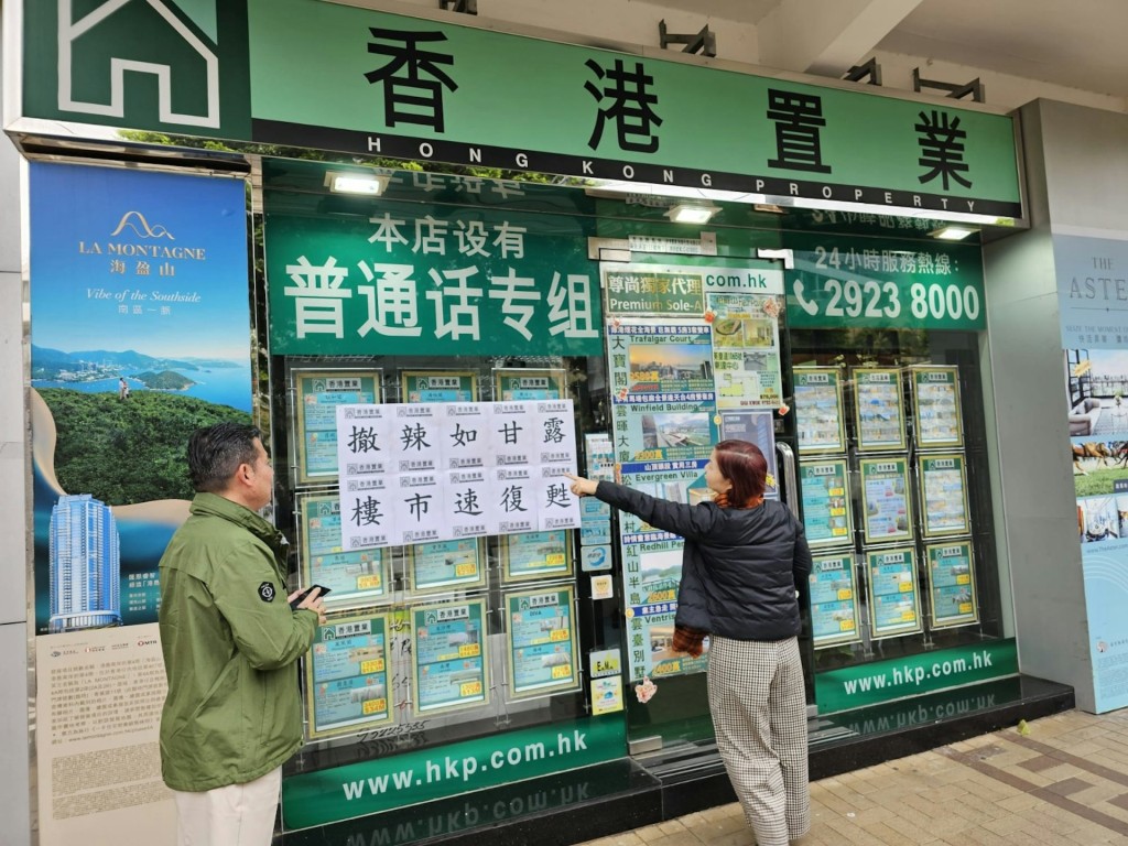 香港置业有分行张贴口号「撤辣如甘露 楼市速复苏」。