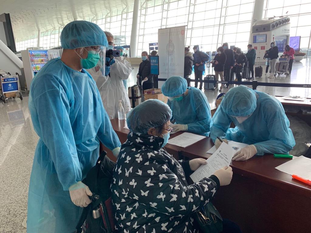 負責登記和處理防疫包的人員與昨日一樣,穿上藍色保護服裝和頭套,並佩戴口罩及防疫膠片。