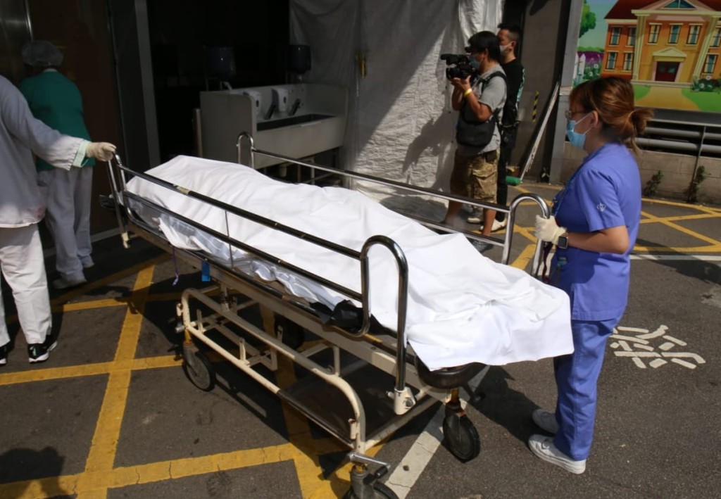 死者遺體舁送殮房。