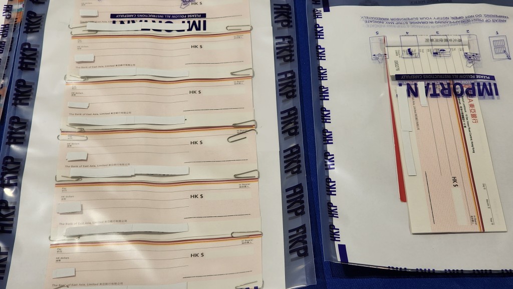 警方檢獲多部手提電話、多張他人香港身份證、空頭支票及支票簿等。 警方檢獲多部手提電話、多張他人香港身份證、空頭支票及支票簿等。
