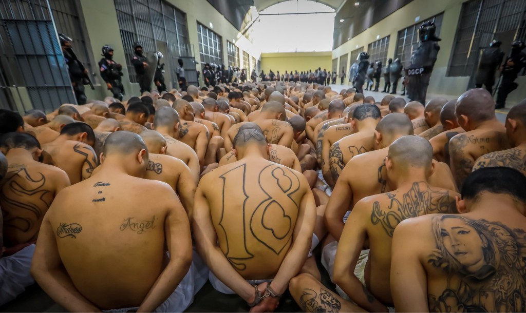 囚犯人貼人蹲下來等候安排進入牢房。 路透社