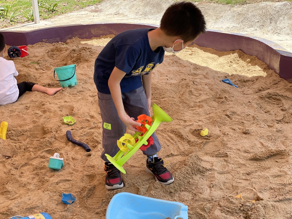 儿童乐园旁有小沙池，是小朋友至爱之一。