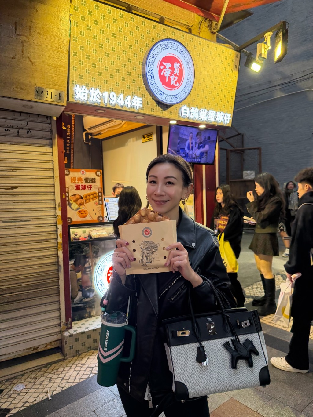 區文詩品嚐街頭小吃。