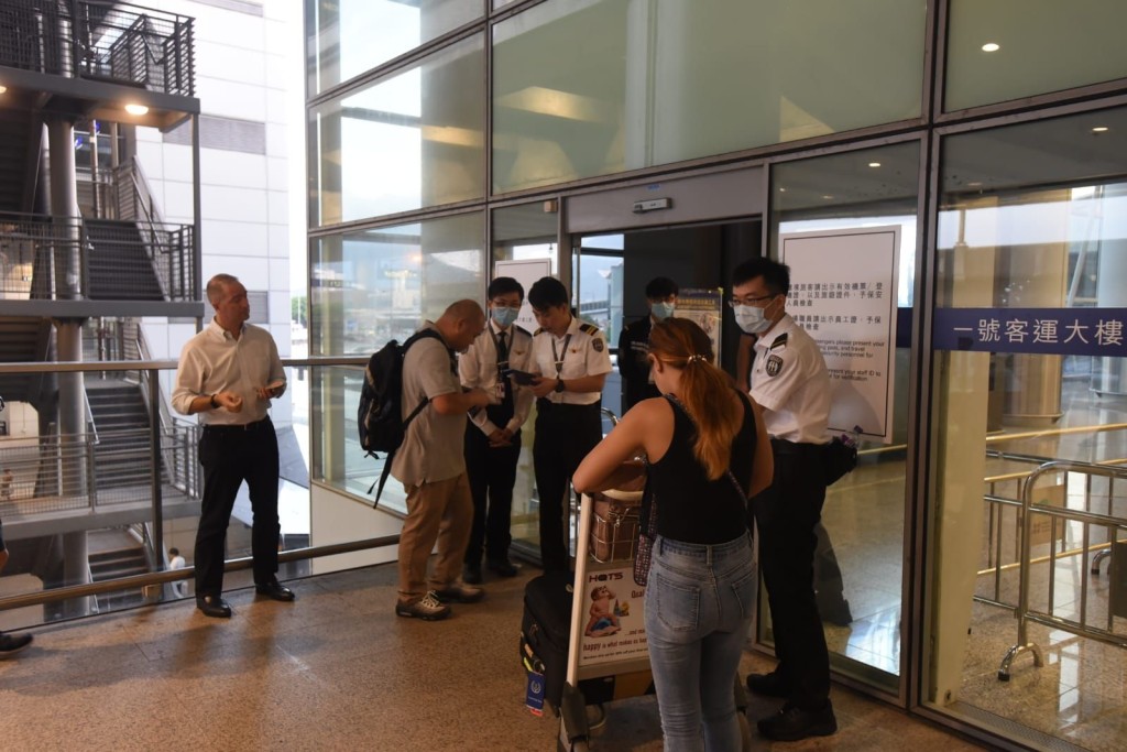 機場保安人員檢查進入大樓人士的證件及機票