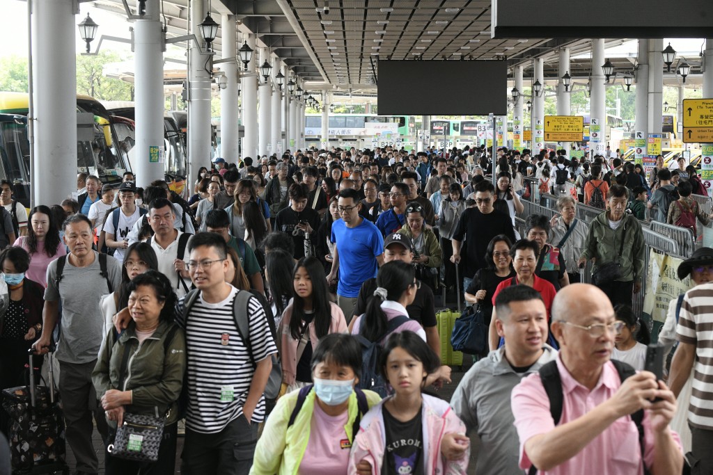 大批旅客排隊等候巴士出市區。
