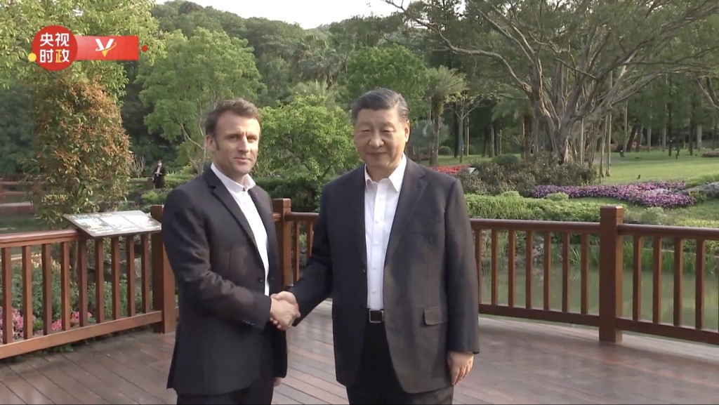 习近平与马克龙在广州松园非正式会晤，两人亲切握手。 央视截图