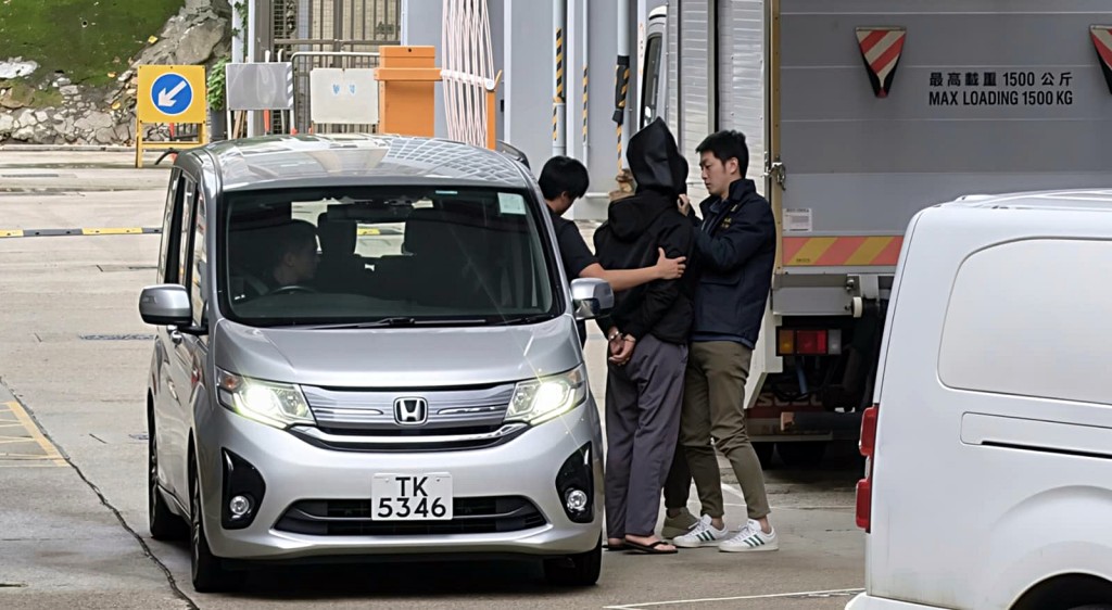 探員押解黑布蒙頭的「左口」。曾志恆攝 探員押解黑布蒙頭的「左口」。曾志恆攝