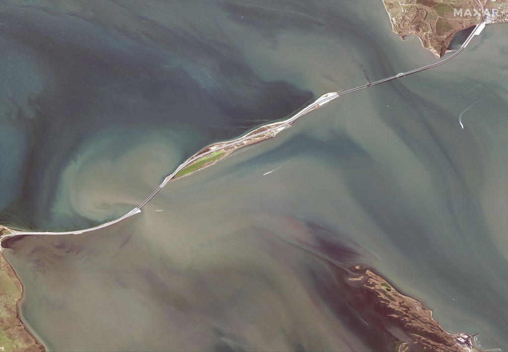 卫星图像显示了连接克里米亚半岛的刻赤桥（右上）与俄罗斯（左下）穿过黑海和亚速海之间的海峡的损坏。AP