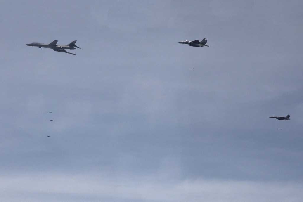 在韩美联合空中演习期间，美国空军B-1B轰炸机（左）和韩国战斗机F-15K飞越朝鲜半岛。 南韩国防部